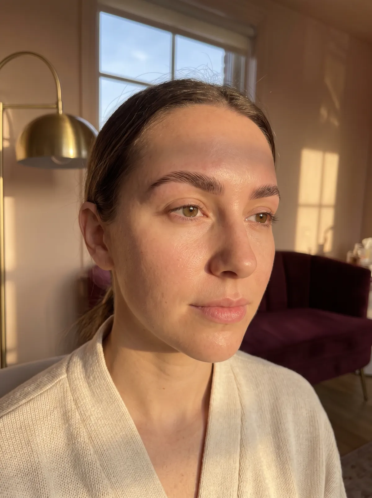Close-up of full, softly laminated brows on a client, natural light