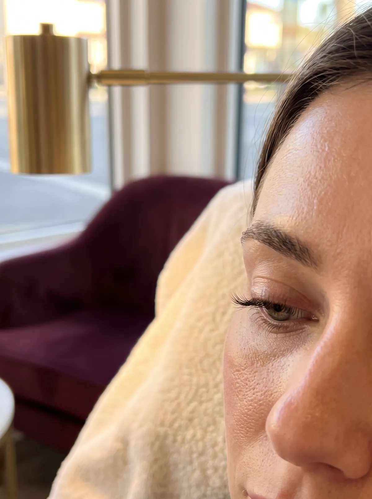 Close-up of lifted, tinted natural lashes on a client's eye looking down, minimal makeup