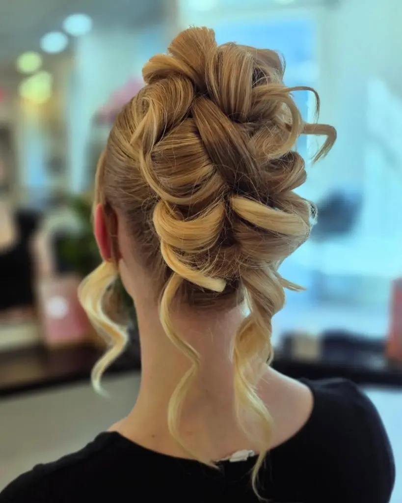 A blonde textured updo with loose curled pieces