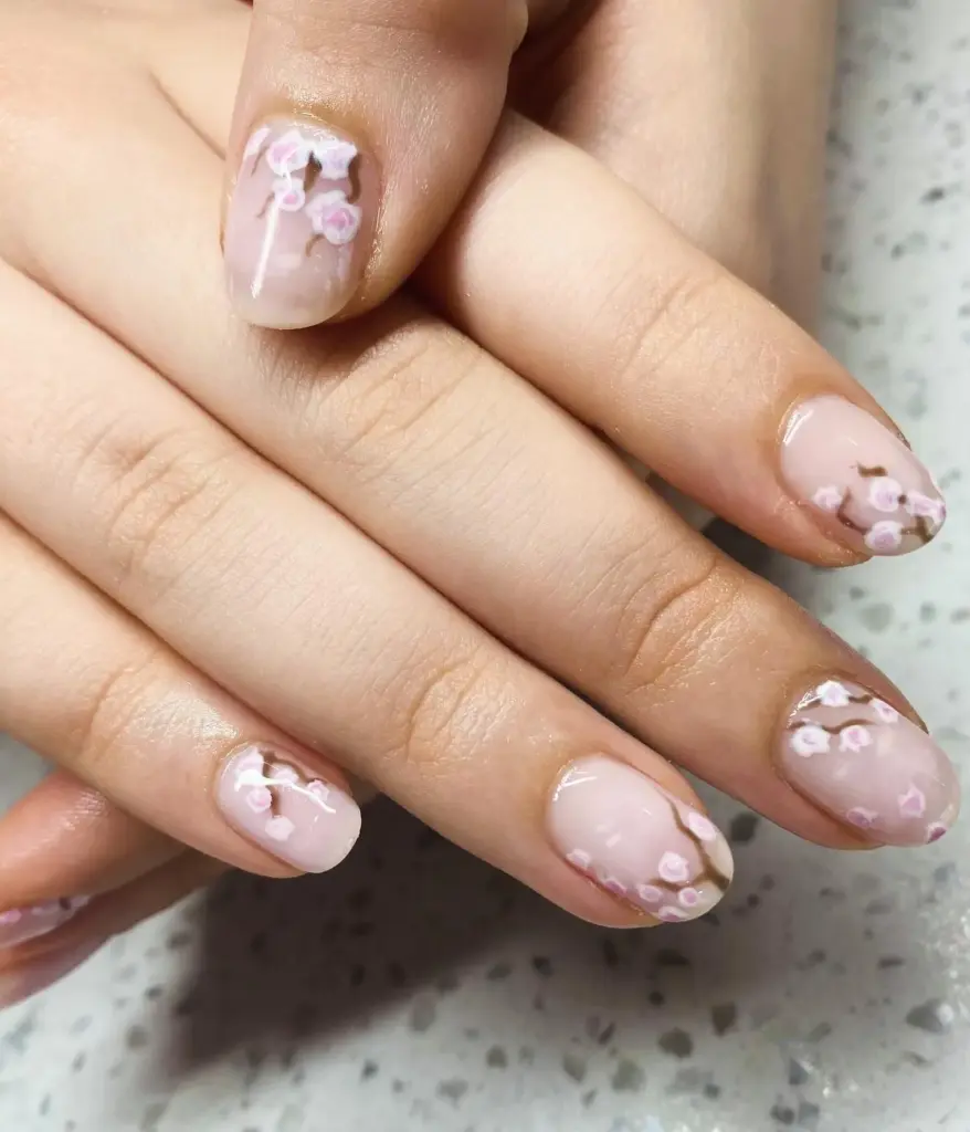 Sheer pink nails with hand-painted cherry blossoms