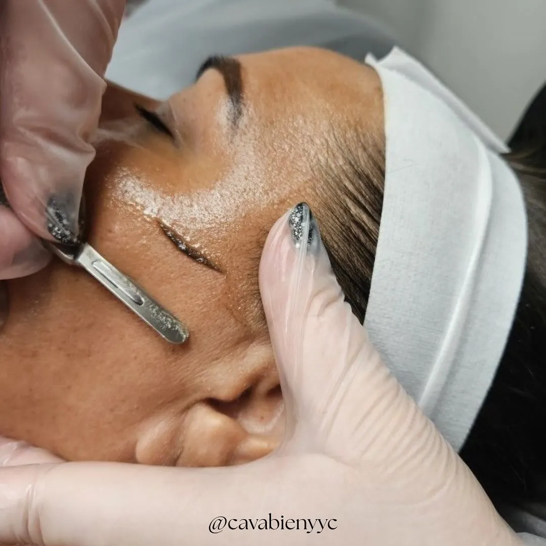An esthetician working on a client's skin during a facial