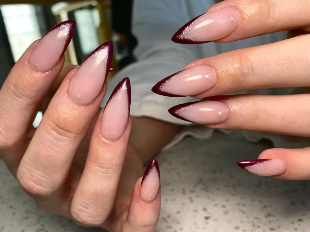 Almond nails in nude with burgundy French tips