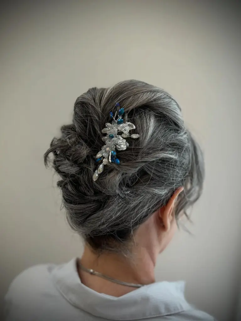 Silver hair in a textured updo with a jewelled pin