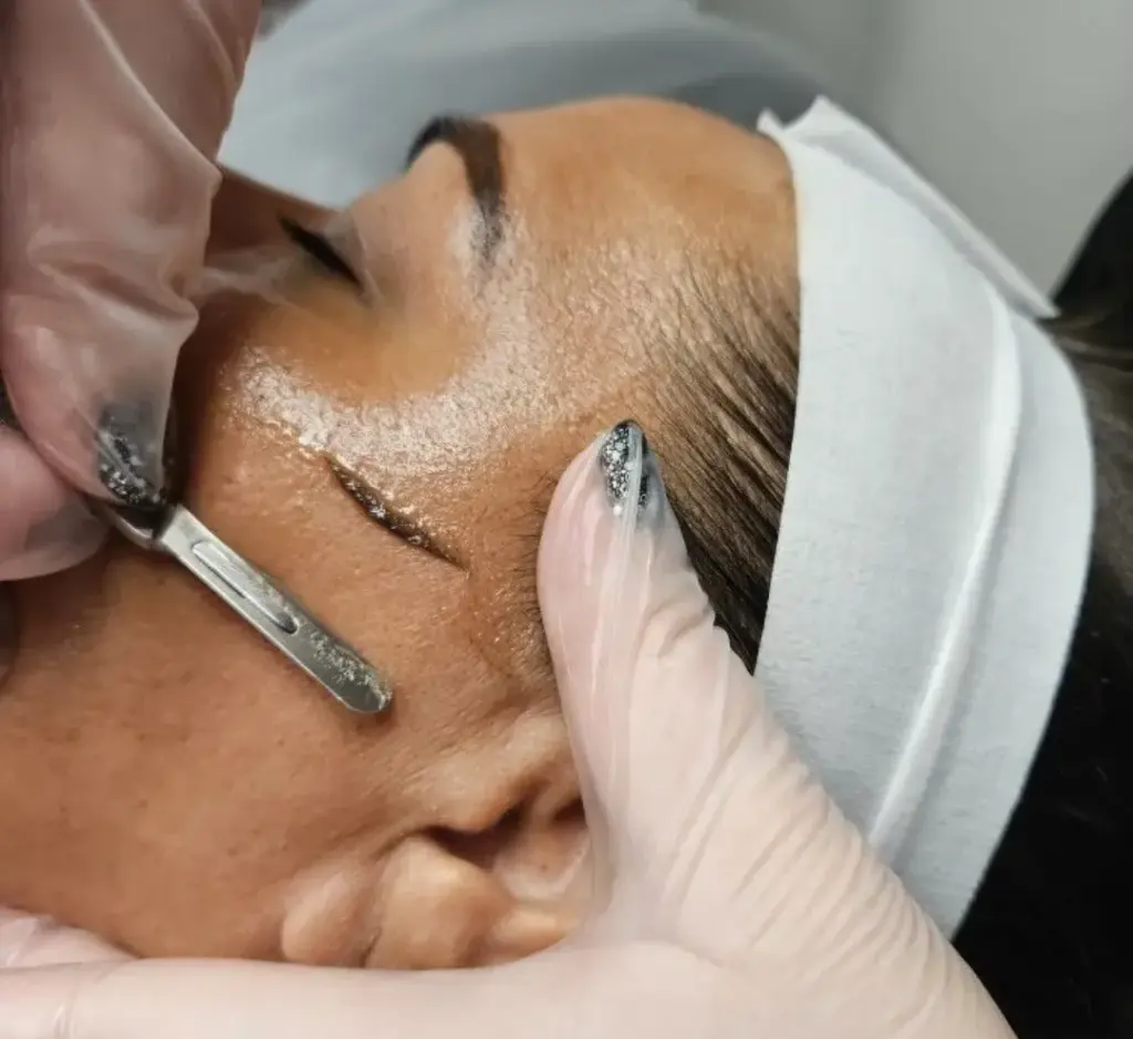 An esthetician working on a client's skin during a facial